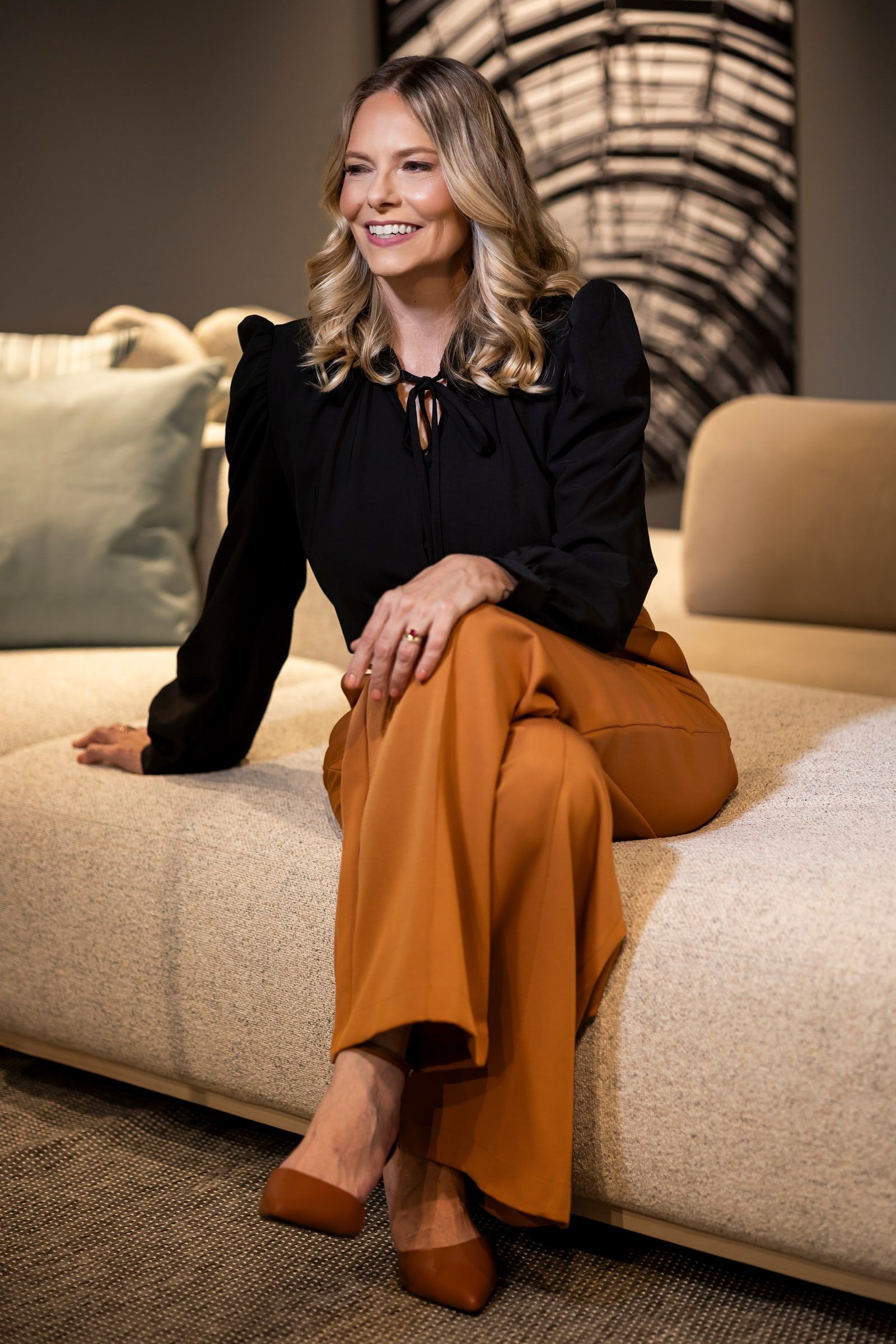 Dra. Ingrid Kibelkstis sentada, sorrindo, em ambiente de trabalho